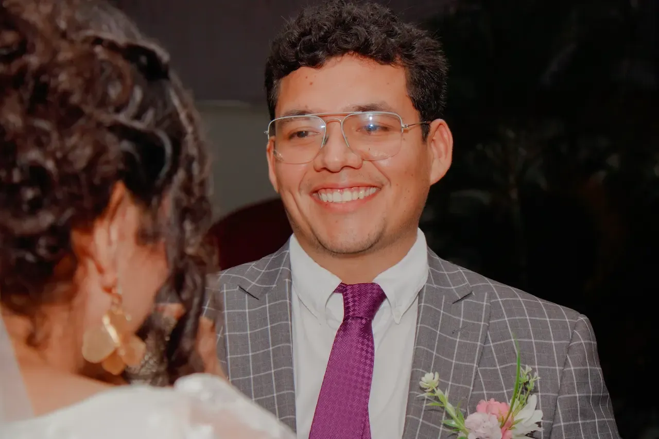 La pareja de novios sosteniendo un cartel de Kiss Cam