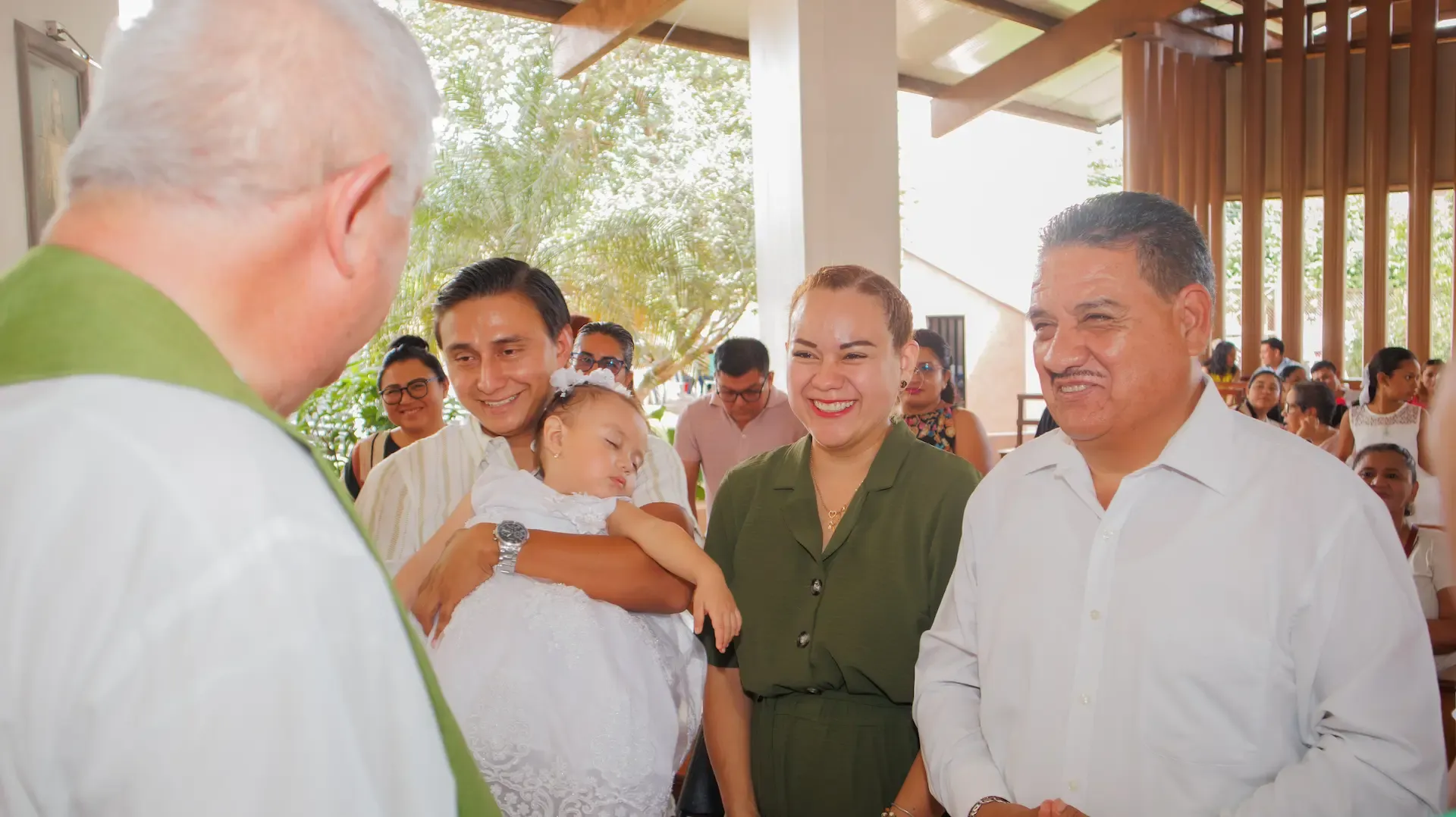 El bebé siendo sostenido por su familia