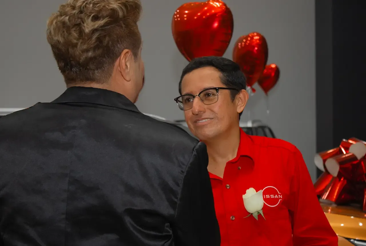 Un vendedor de Nissan conversando con un hombre de traje negro