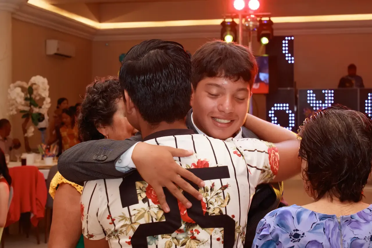 El quinceañero abrazando a un joven
