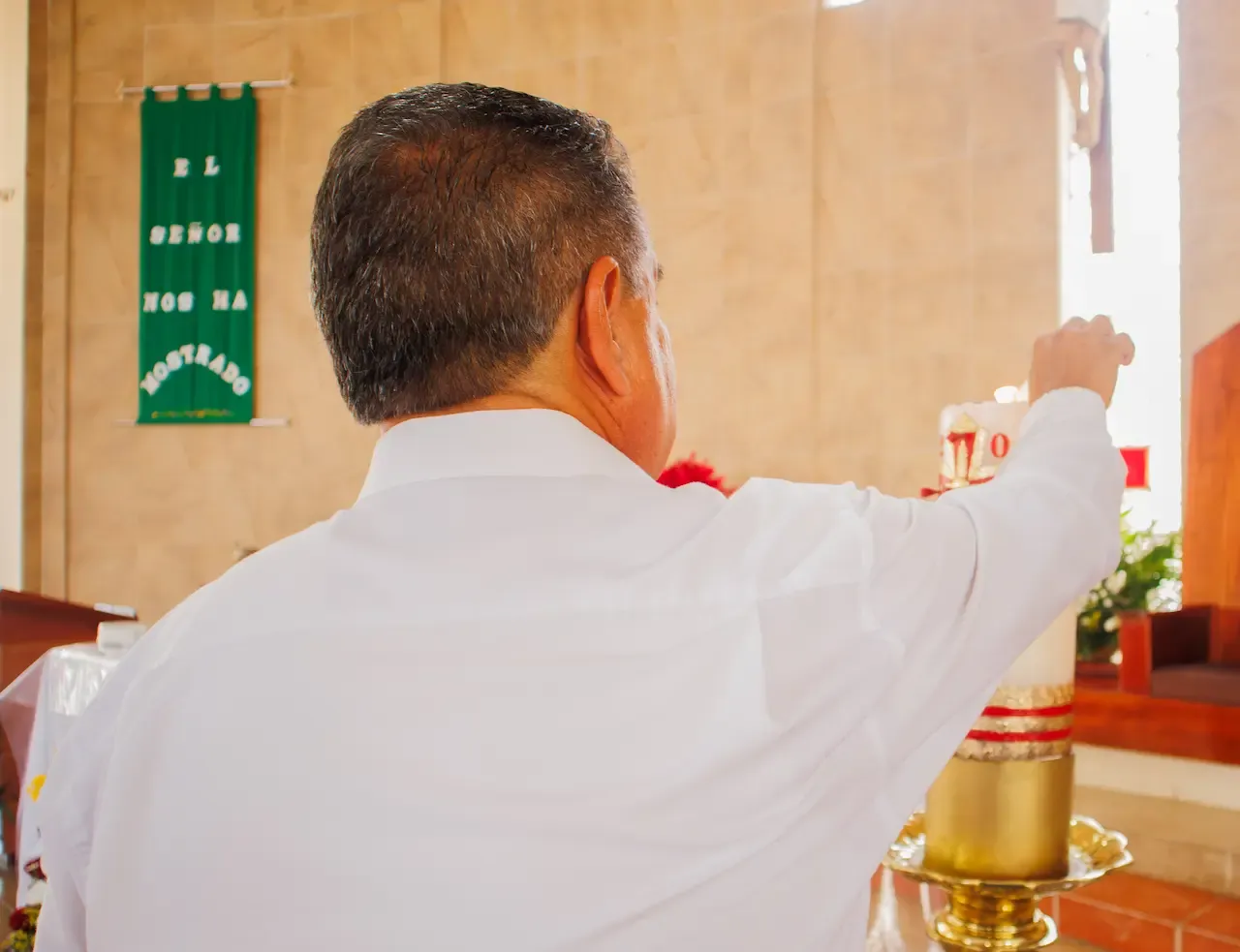 Foto del padre de espaldas tocando una vela
