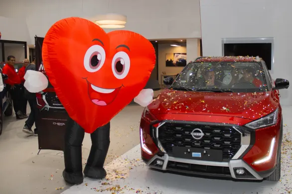 Un carro Nissan al lado de una botarga con forma de corazón