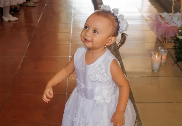 Madre sosteniendo a su bebé durante el bautizo